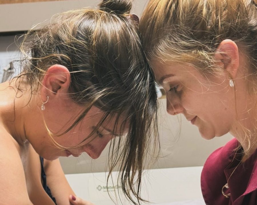 Dra. Aline Bonanato com a testa encostada na de uma paciente em trabalho de parto, no Mater Dei